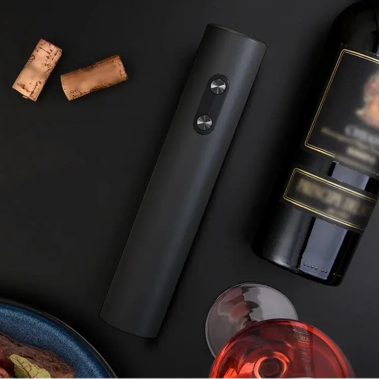 Electric wine opener set displayed with wine bottles and corks on a dark surface.