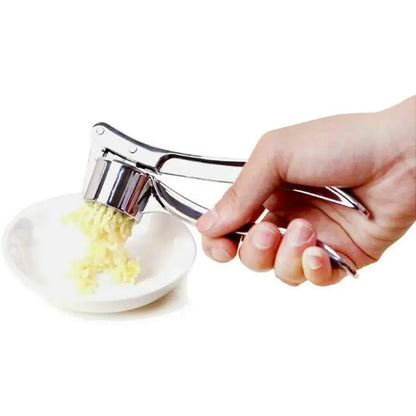 Garlic Press – Silky Mince For Effortless Prep + Heavy-Duty Zinc Alloy Construction hand-held stainless steel garlic crusher pressing minced garlic into bowl