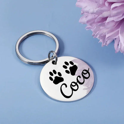 Dog Tag – Permanent Engraving For Legibility + Stainless Steel Quick Release Attachment, round engraved pet tag with paw prints and name "Coco"