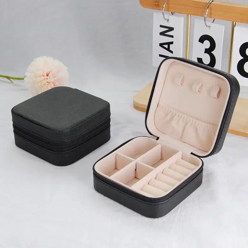 Compact travel jewelry organizer, leather travel case with compartments for rings and earrings.