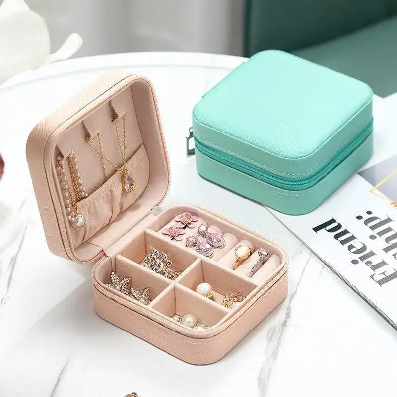 Compact travel jewelry organizer featuring a stylish leather case with compartments for rings and earrings.