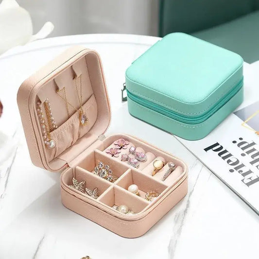 Compact travel jewelry organizer featuring a stylish leather case with compartments for rings and earrings.