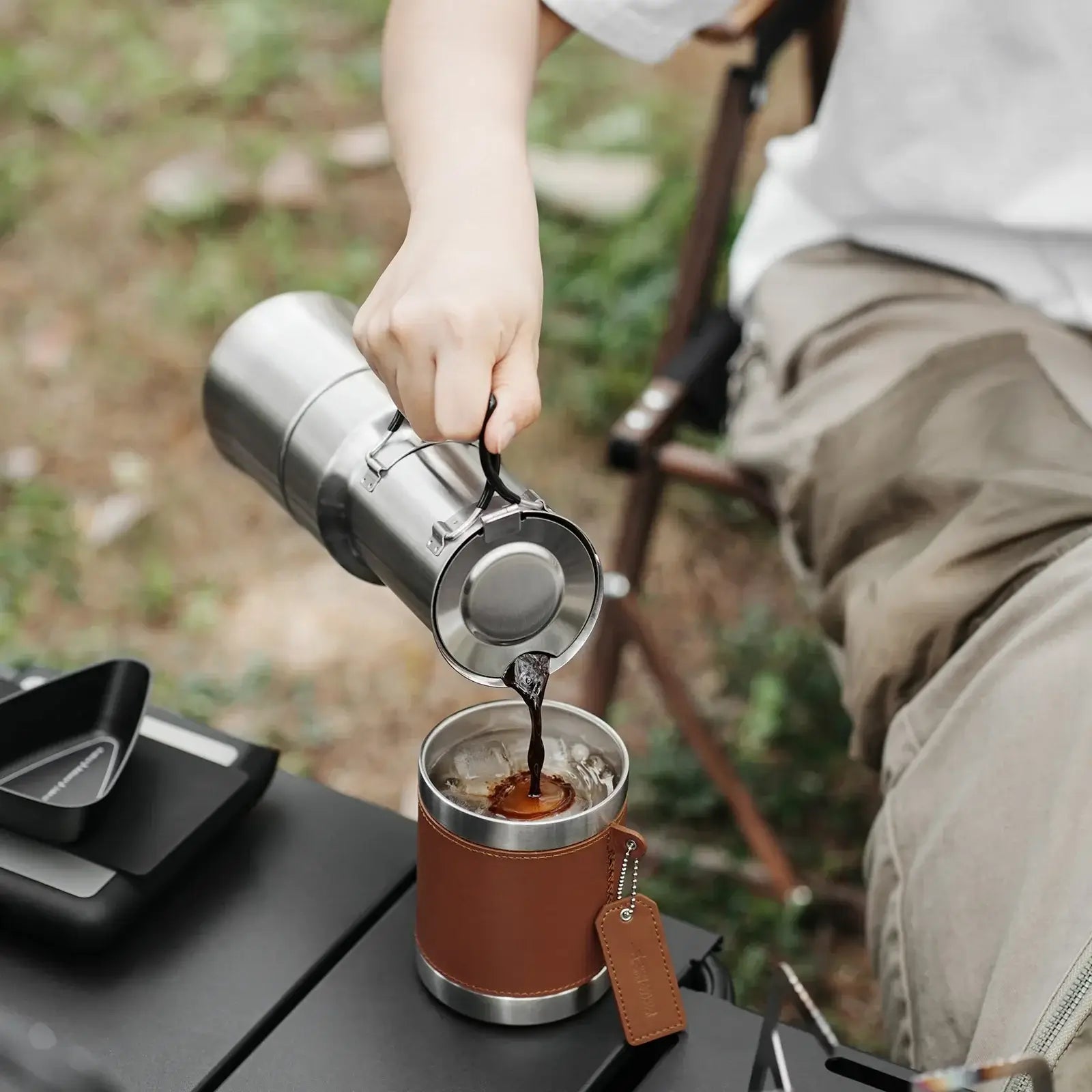 Stainless Steel Moka Pot – Rich Coffee + Foldable Handle pouring fresh moka coffee into camp cup, 350ml camping coffee maker