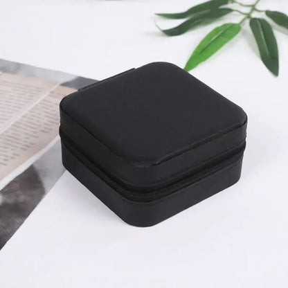 Compact travel jewelry organizer in sleek black leather, perfect for storing rings and small jewelry on the go.