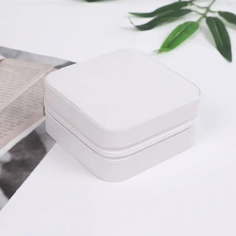 Compact travel jewelry organizer in white leather, perfect for storing rings and small jewelry while traveling.