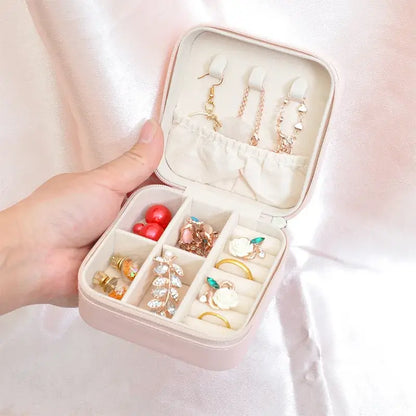 Compact travel jewelry organizer with earrings and rings in a stylish leather box, perfect for travel.