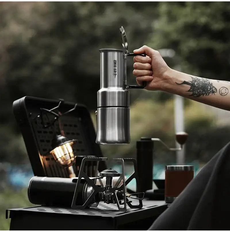 Stainless Steel Moka Pot – Rich Coffee + Foldable Handle in hand over camp stove, 350ml outdoor moka pot