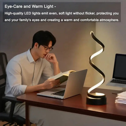 Person reading with an adjustable brightness LED spiral lamp on desk, creating a warm and comfortable atmosphere.