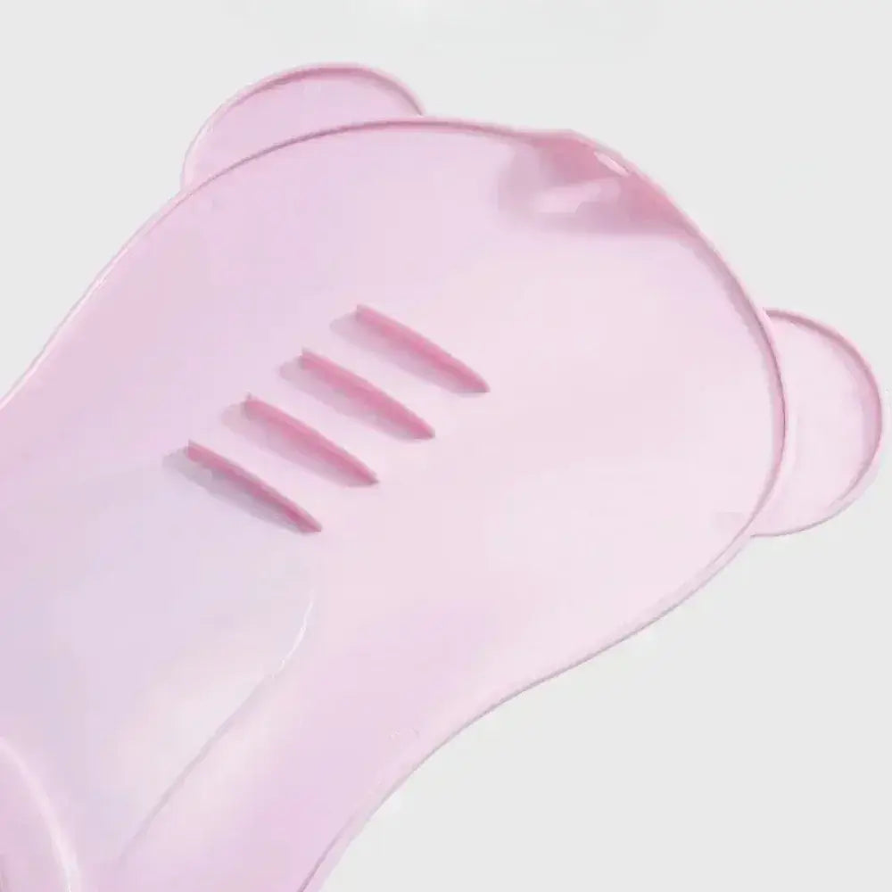 Non-slip baby bath seat in soft pink design featuring bear ears and grooves for added comfort and safety.
