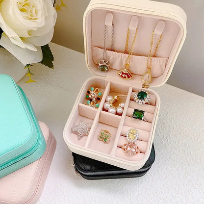 Compact travel jewelry organizer filled with rings, earrings, and necklaces in a stylish leather case.