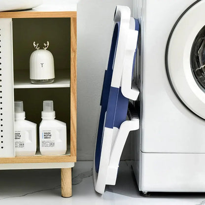 Foldable newborn baby bath tub stored neatly next to a washing machine in a stylish bathroom.