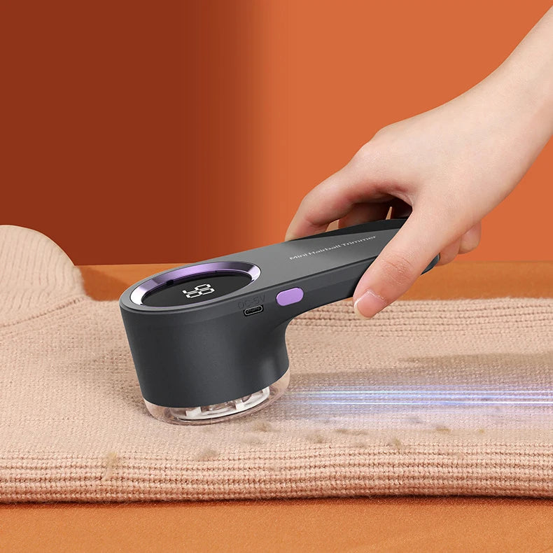 USB rechargeable fabric shaver with LED display removing lint from a sweater.